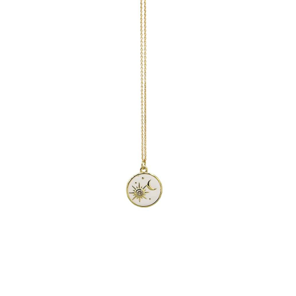 A delicate gold chain necklace featuring a small circular pendant with a white background and a gold celestial sun and moon design, shown against a plain white background.