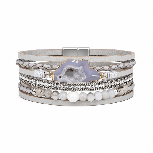 A multi-layered wrap bracelet featuring a light gray leather band, braided silver cords, a row of clear rhinestones, white pearl-like beads, and a central lavender-gray agate geode accent, shown on a plain white background.