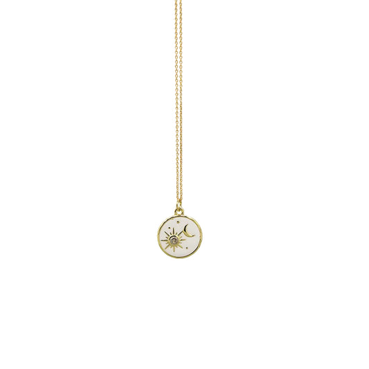 A delicate gold chain necklace featuring a small circular pendant with a white background and a gold celestial sun and moon design, shown against a plain white background.