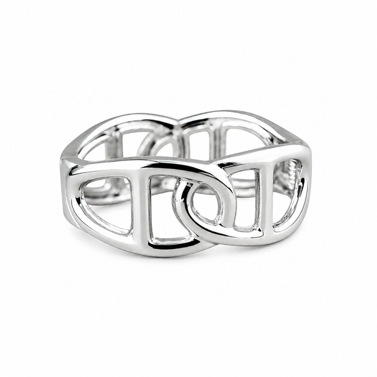 A polished silver-toned ring with an open, interlocking geometric design, photographed on a clean white background.